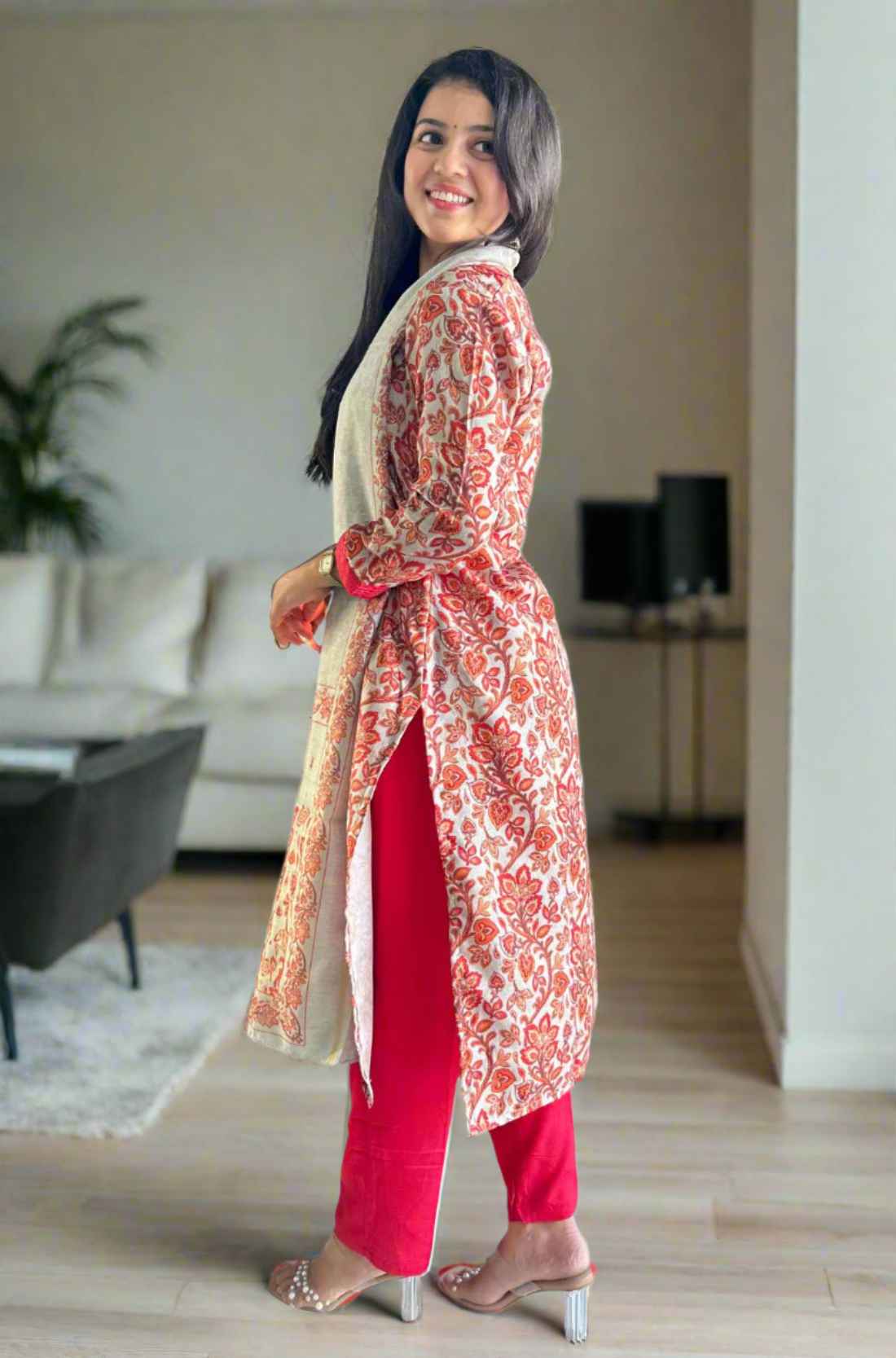 Side pose in red kurta with printed circles and red dupatta.