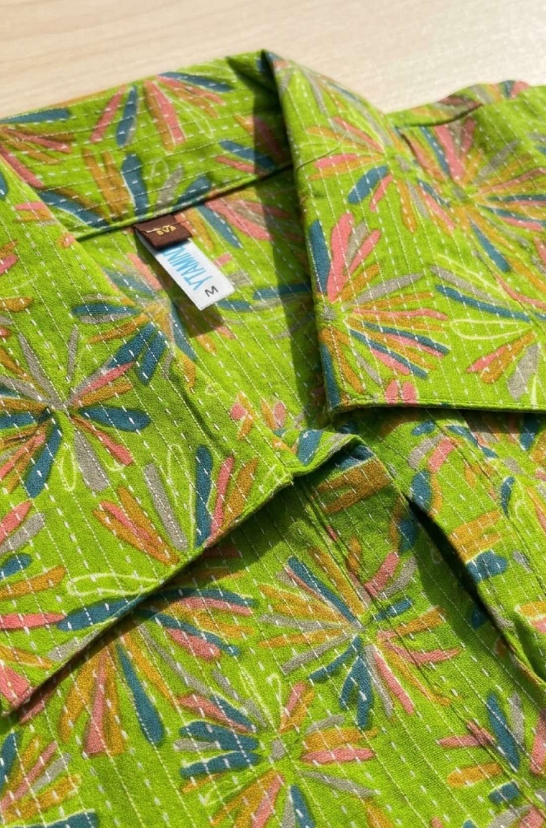 Close-up of the collar neckline showcasing the Jaipur floral print and white Kantha stitch detailing on the lime green pure cotton dress.