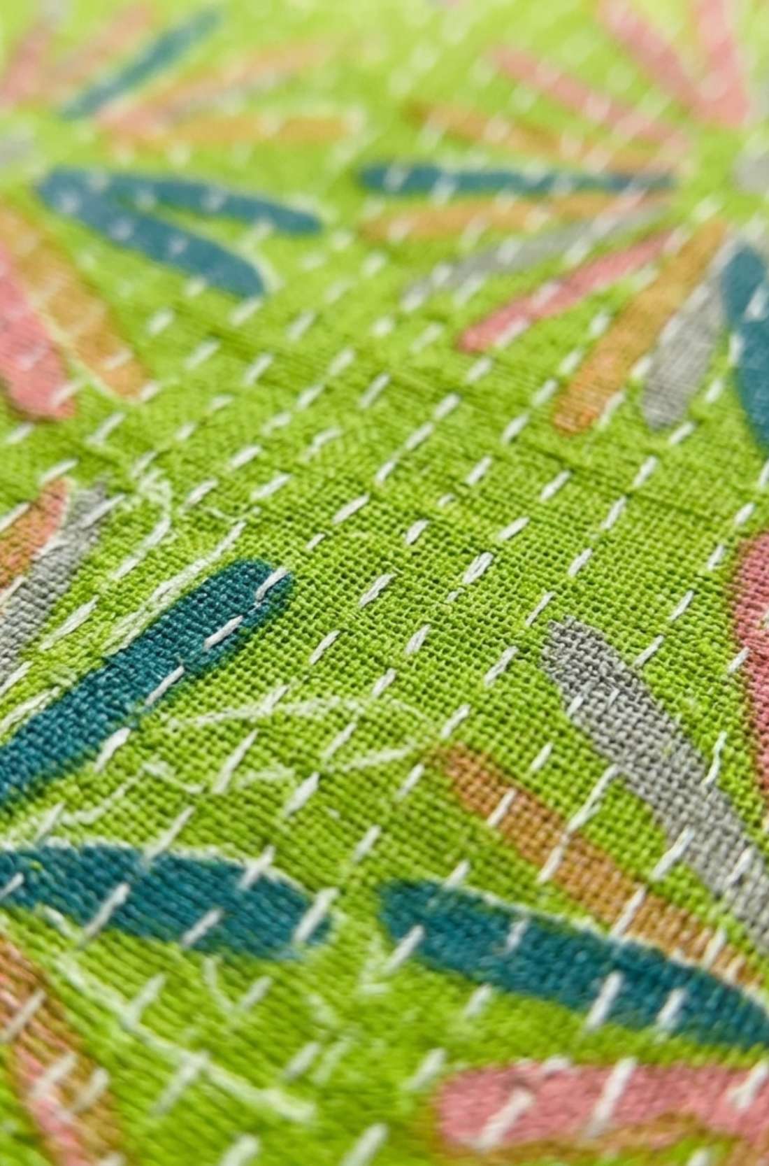 Macro view of the breathable pure cotton fabric featuring colourful Jaipur floral print and traditional white Kantha stitch detailing.