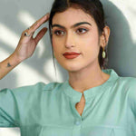 Close-up of the mandarin collar, front button placket, and elegant pleated detailing on a women's sea green rayon formal shirt.