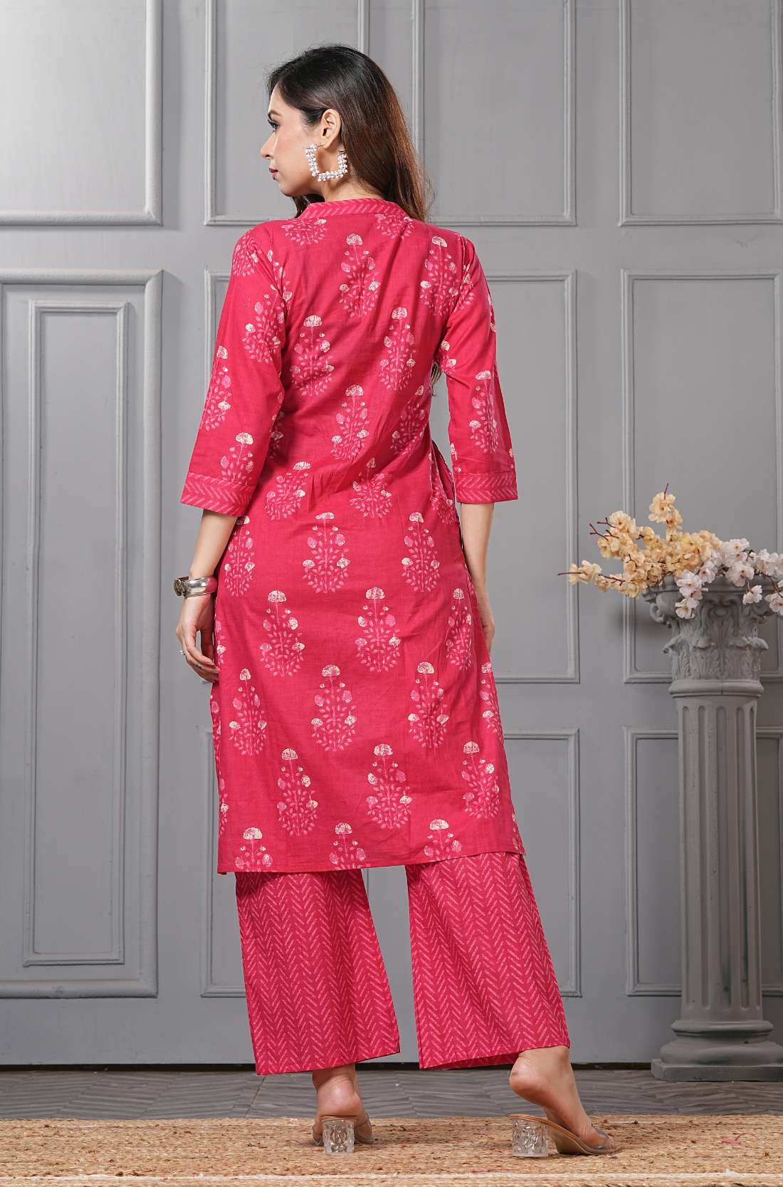 Rear view of the solid wine-colored kurta - highlighting the matching embroidered cuffs - and the structured silhouette of the straight-leg pants.