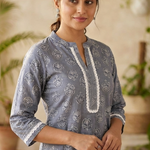 Front view of women's grey cotton straight-fit kurti featuring white block print motifs, a round neckline with lace-accented yoke, three-quarter sleeves with lace cuffs, and breathable cotton fabric.