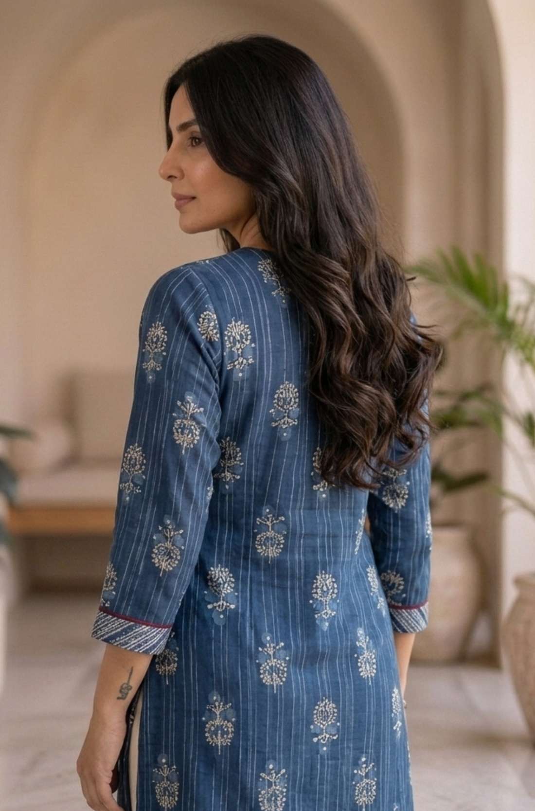 Back view of women's indigo pure cotton straight-fit kurta with white floral hand block print motifs, three-quarter sleeves, side slits, and a clean back design.
