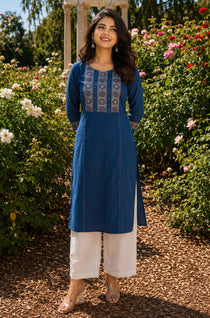 Woman wearing an indigo pure cotton hand block print kurta with mirror work yoke, round neckline and three-quarter sleeves.