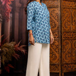 Side profile of powder blue pure cotton short kurti showcasing hand block printed floral motifs, relaxed silhouette, 3/4 sleeves and curved hem for casual ethnic wear.