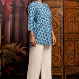 Side profile of powder blue pure cotton short kurti showcasing hand block printed floral motifs, relaxed silhouette, 3/4 sleeves and curved hem for casual ethnic wear.
