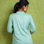 Back view of women's sea green rayon shirt with a mandarin collar, half sleeves, relaxed silhouette, and smooth back design for office and casual wear.