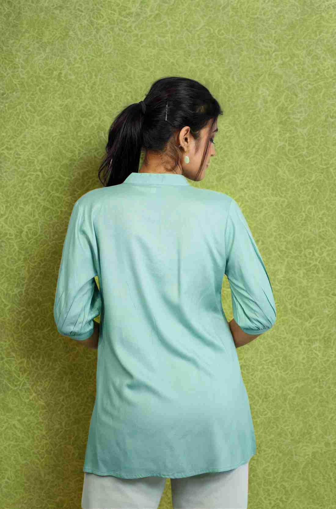 Back view of women's sea green rayon shirt with a mandarin collar, half sleeves, relaxed silhouette, and smooth back design for office and casual wear.