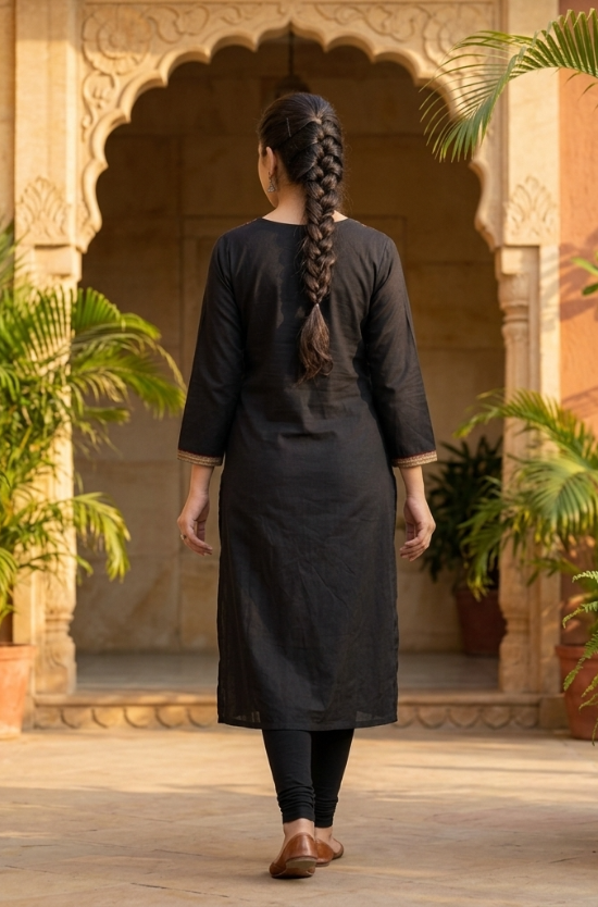 A woman seen from the back, showcasing the simple black straight kurta and her braided hairstyle.