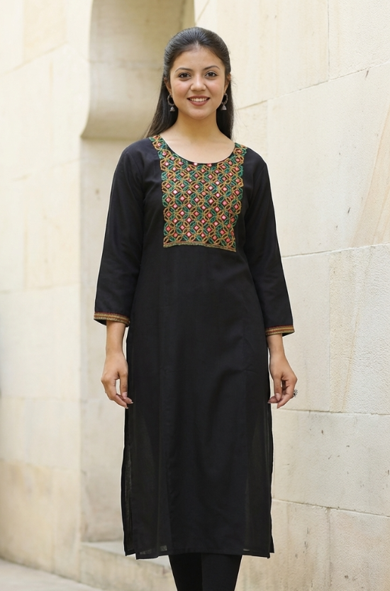 A front-facing studio shot of a woman modeling a black straight-cut kurta with mirror-work detailing.