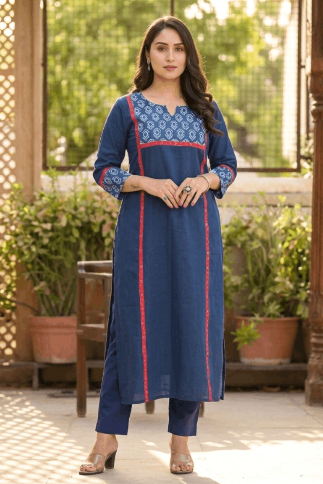 Full length front view of a woman posing gracefully in a blue ethnic wear set with floral print details.