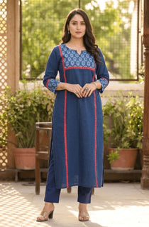 Full length front view of a woman posing gracefully in a blue ethnic wear set with floral print details.