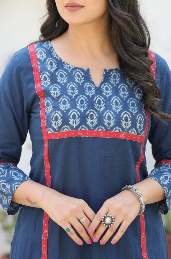 Close-up of a blue cotton kurta featuring a floral printed yoke with striking red border detailing.