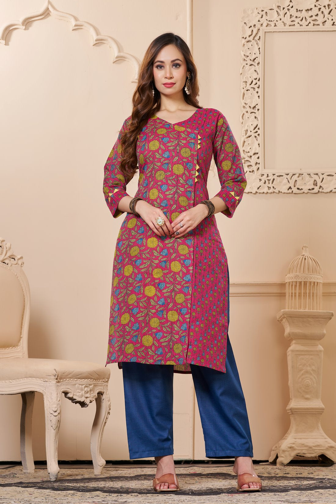 Front full length view of a model wearing a bright pink cotton floral print kurta set with matching pocketed straight pants