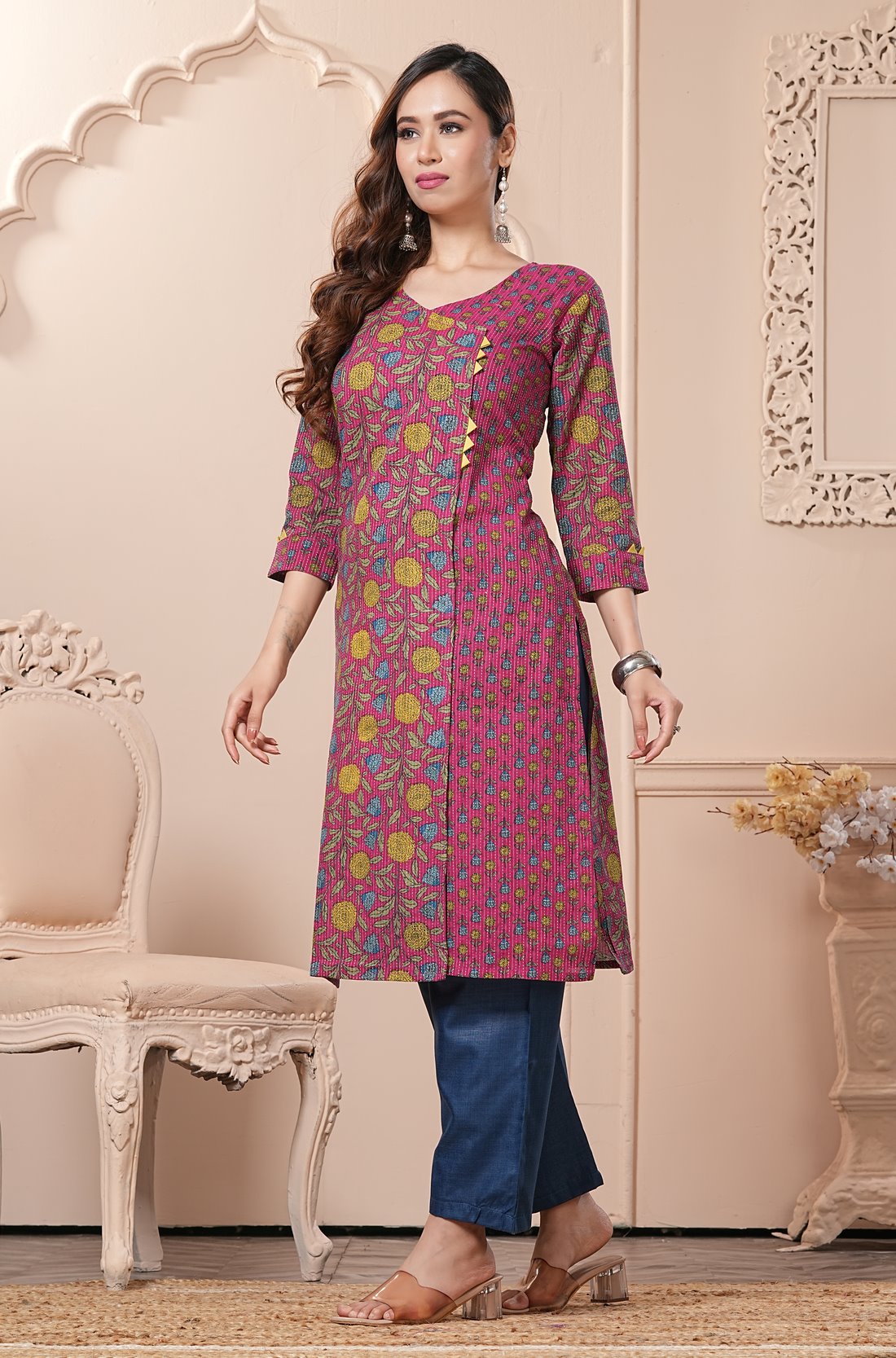 Side profile view of a model in a bright pink floral printed cotton ethnic suit showcasing the clean straight-cut fall