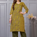 Front full length view of a model wearing a mustard yellow cotton floral print kurta set with matching pocketed straight pants