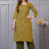 Front full length view of a model wearing a mustard yellow cotton floral print kurta set with matching pocketed straight pants