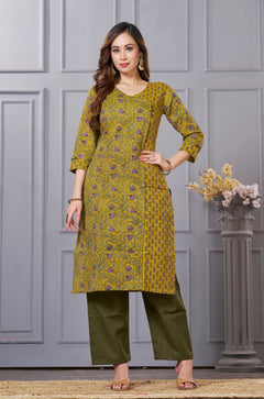 Front full length view of a model wearing a mustard yellow cotton floral print kurta set with matching pocketed straight pants