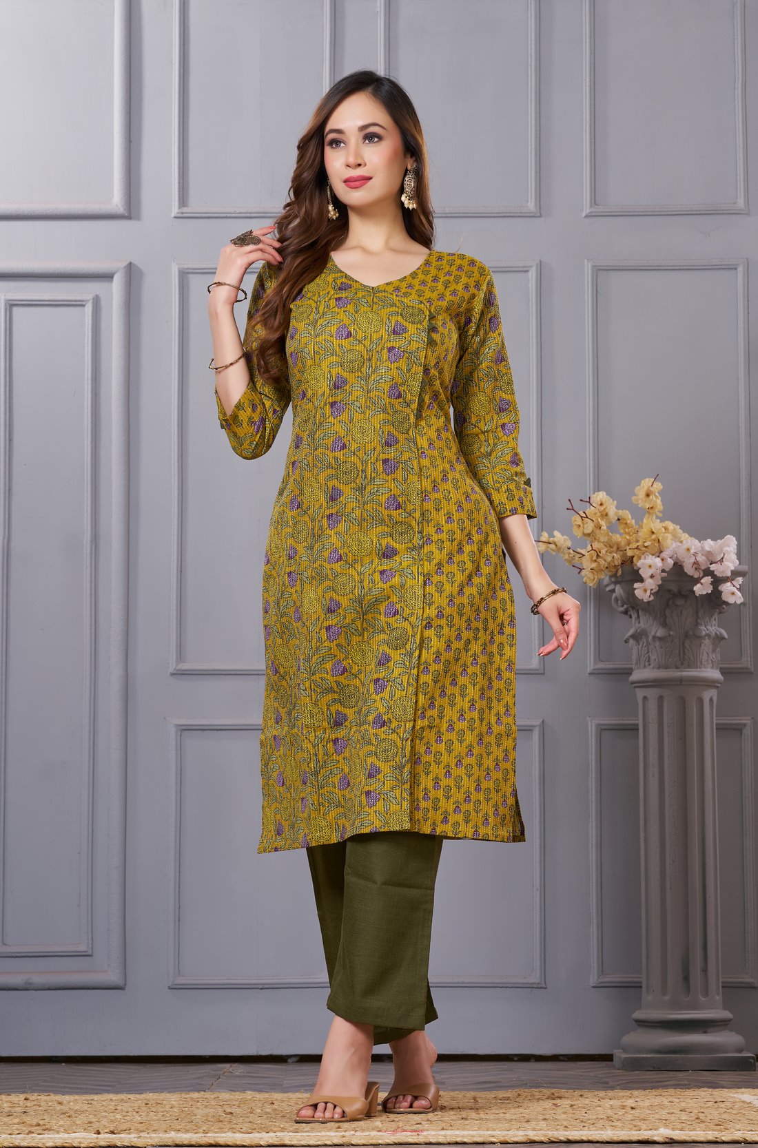 Side profile view of a model in a mustard yellow floral printed cotton ethnic suit showcasing the regular fit and elegant side slit profile