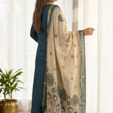 Side profile view of a model in a dark blue silk ethnic suit set with matching pants and a draped chanderi dupatta