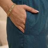 Close-up view highlighting the convenient functional side utility pocket tailored into the matching dark blue silk straight trousers, showing a hand resting inside the pocket.