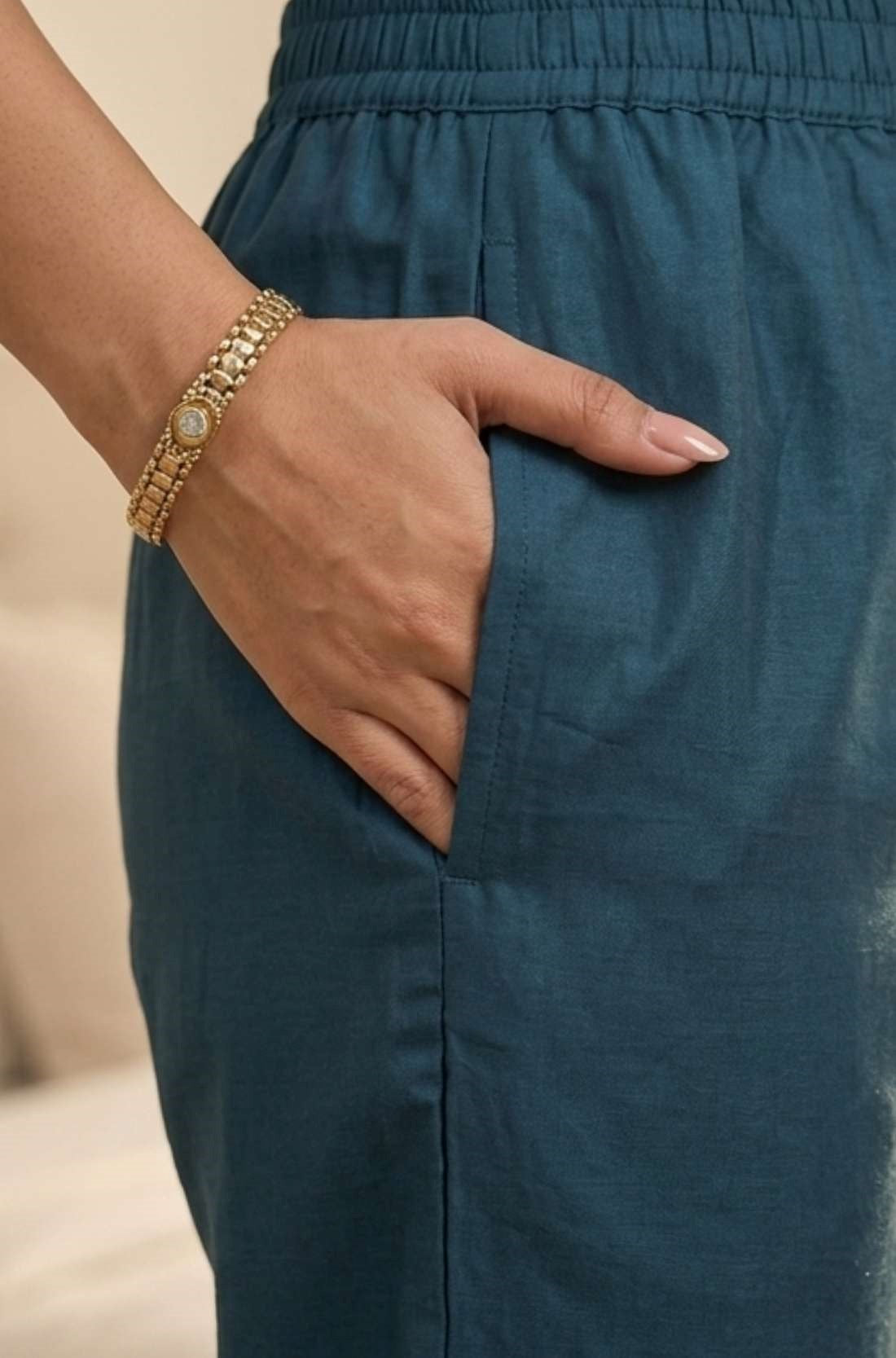 Close-up view highlighting the convenient functional side utility pocket tailored into the matching dark blue silk straight trousers, showing a hand resting inside the pocket.
