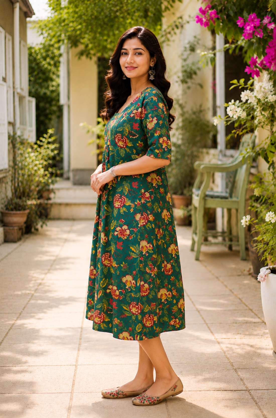 Side profile view of a woman posing in a flared dark green cotton floral print frock-style kurti, highlighting the comfortable elbow-length sleeves and elegant drape.