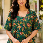 Close-up shot of the front bodice showcasing the unique overlapping V-shaped neckline and center gathering details on a dark green floral printed cotton frock kurti.