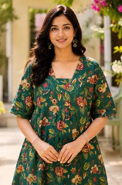 Close-up shot of the front bodice showcasing the unique overlapping V-shaped neckline and center gathering details on a dark green floral printed cotton frock kurti.