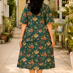 Full-length back view of the dark green cotton printed frock-style kurti, highlighting the continuous floral pattern distribution and the relaxed A-line flare.