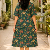 Full-length back view of the dark green cotton printed frock-style kurti, highlighting the continuous floral pattern distribution and the relaxed A-line flare.