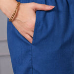 Close-up of blue cotton straight pants with elasticated waistband and side pocket, paired with a bright pink floral cotton kurta for women.