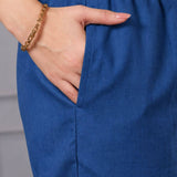 Close-up of blue cotton straight pants with elasticated waistband and side pocket, paired with a bright pink floral cotton kurta for women.