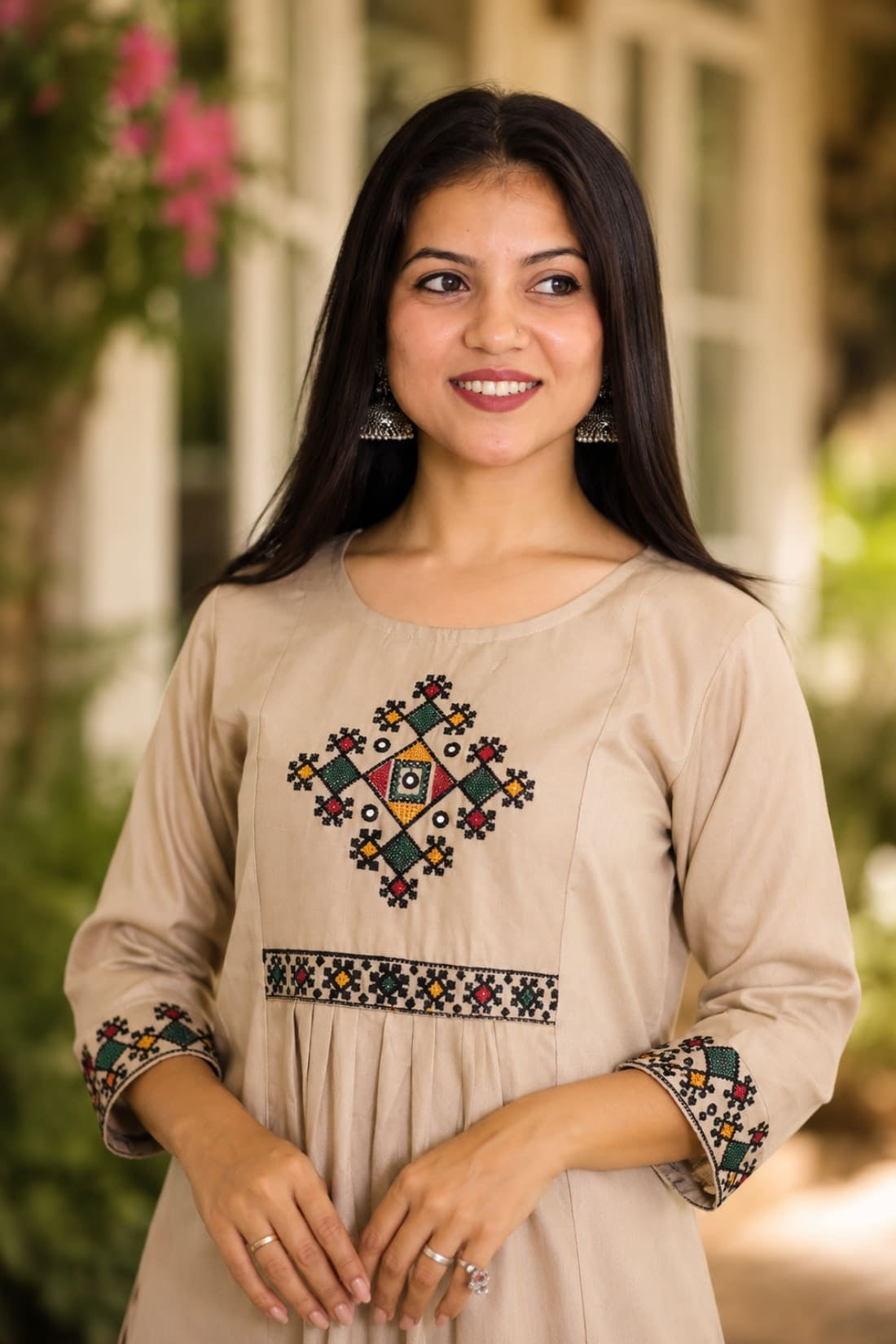 Close-up of beige A-line rayon kurta showing multicolour cross stitch embroidery on yoke and sleeves