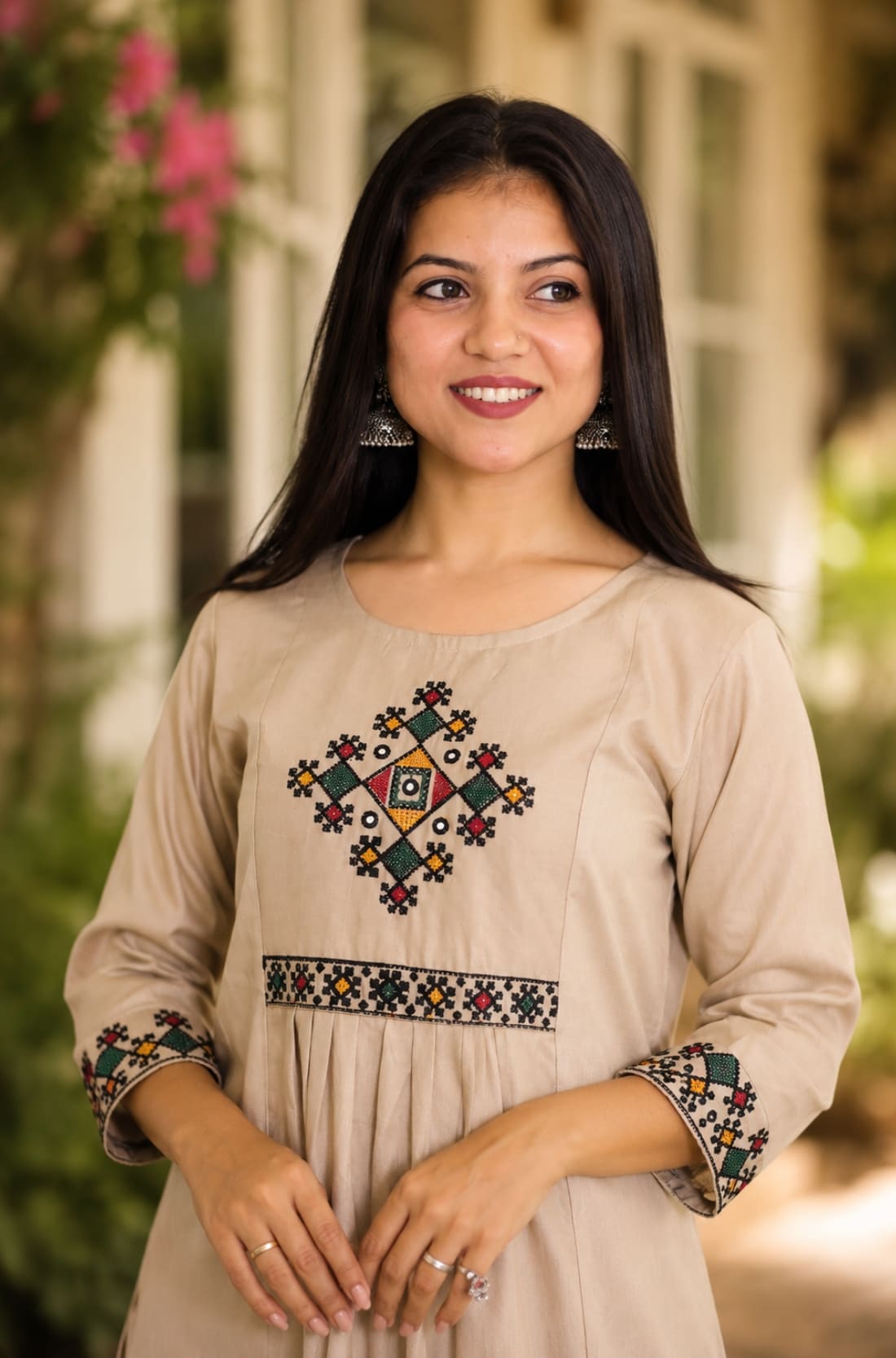 Close-up of beige A-line rayon kurta showing multicolour cross stitch embroidery on yoke and sleeves