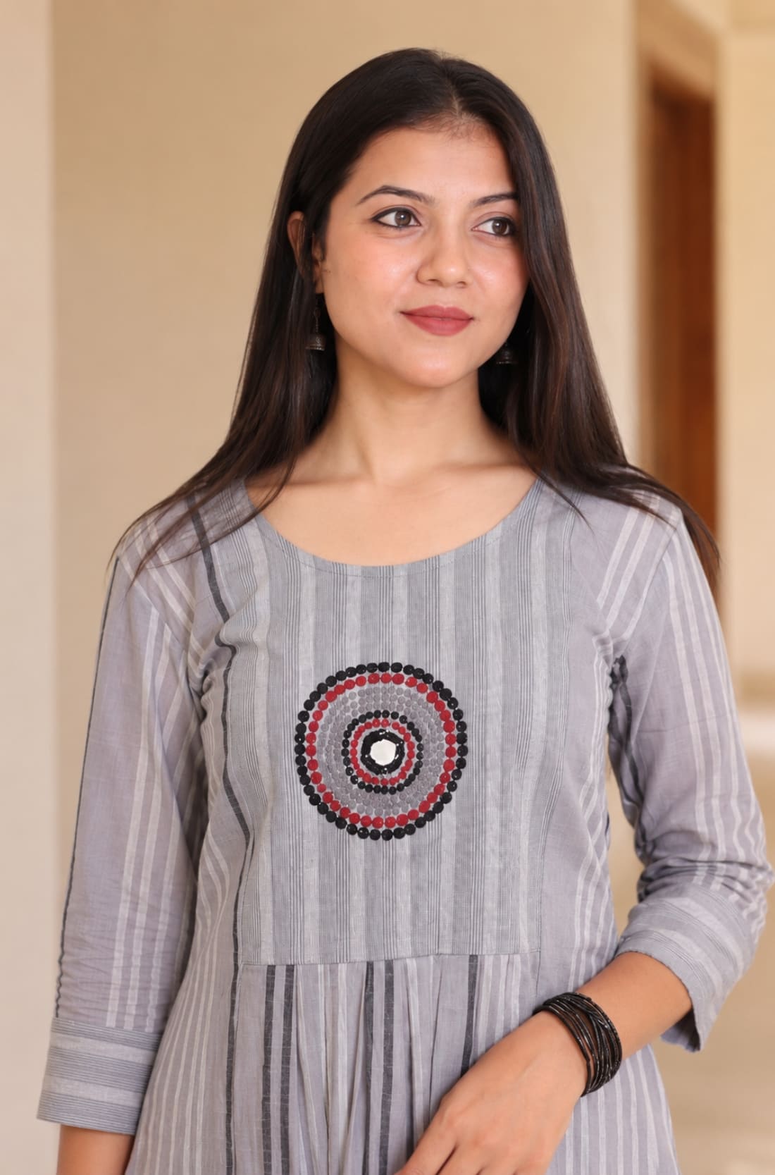 Close-up of grey A-line cotton kurta showing circular embroidery and striped cotton fabric