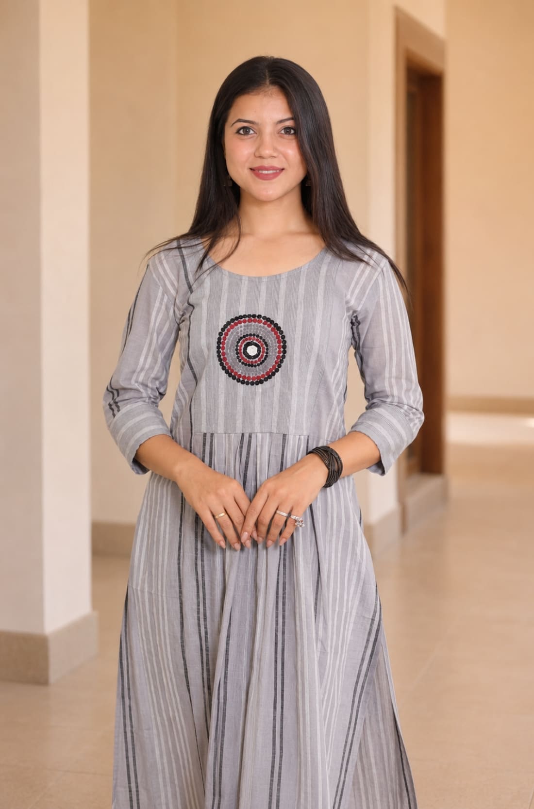 Mid-length front view of grey A-line cotton kurta showing circular embroidery and gathered waist