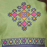 Detailed view of the intricately designed front yoke section on a light green cotton kurta featuring precise geometric and floral cross stitch needlework