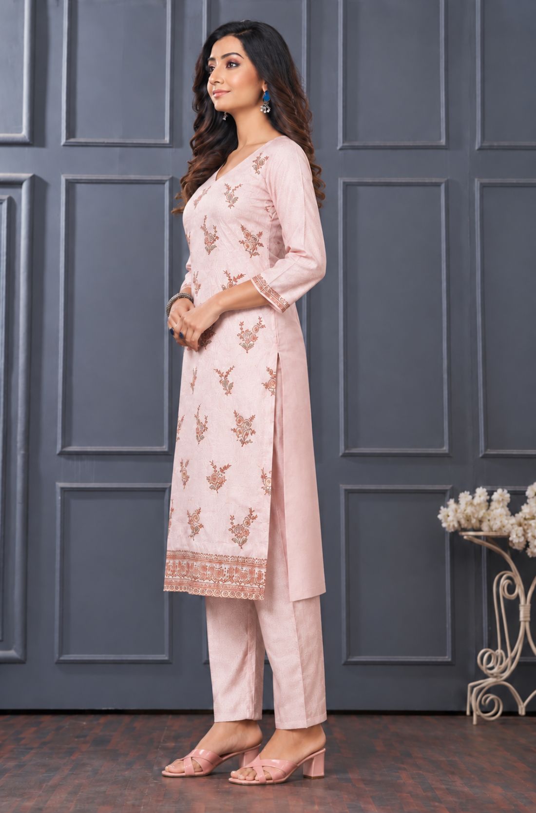Side view of women’s light pink embroidered silk blend kurta set with matching pants.