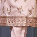 Close-up of floral embroidery and decorative scalloped border on a light pink silk blend kurta for women.
