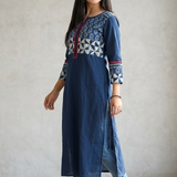 Full body side profile of a woman styling a long blue kurti with side slits and casual blue denim jeans.