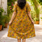 Full back view of the ochre yellow printed cotton frock kurti dress, emphasizing its flowy silhouette and continuous vibrant floral print pattern.