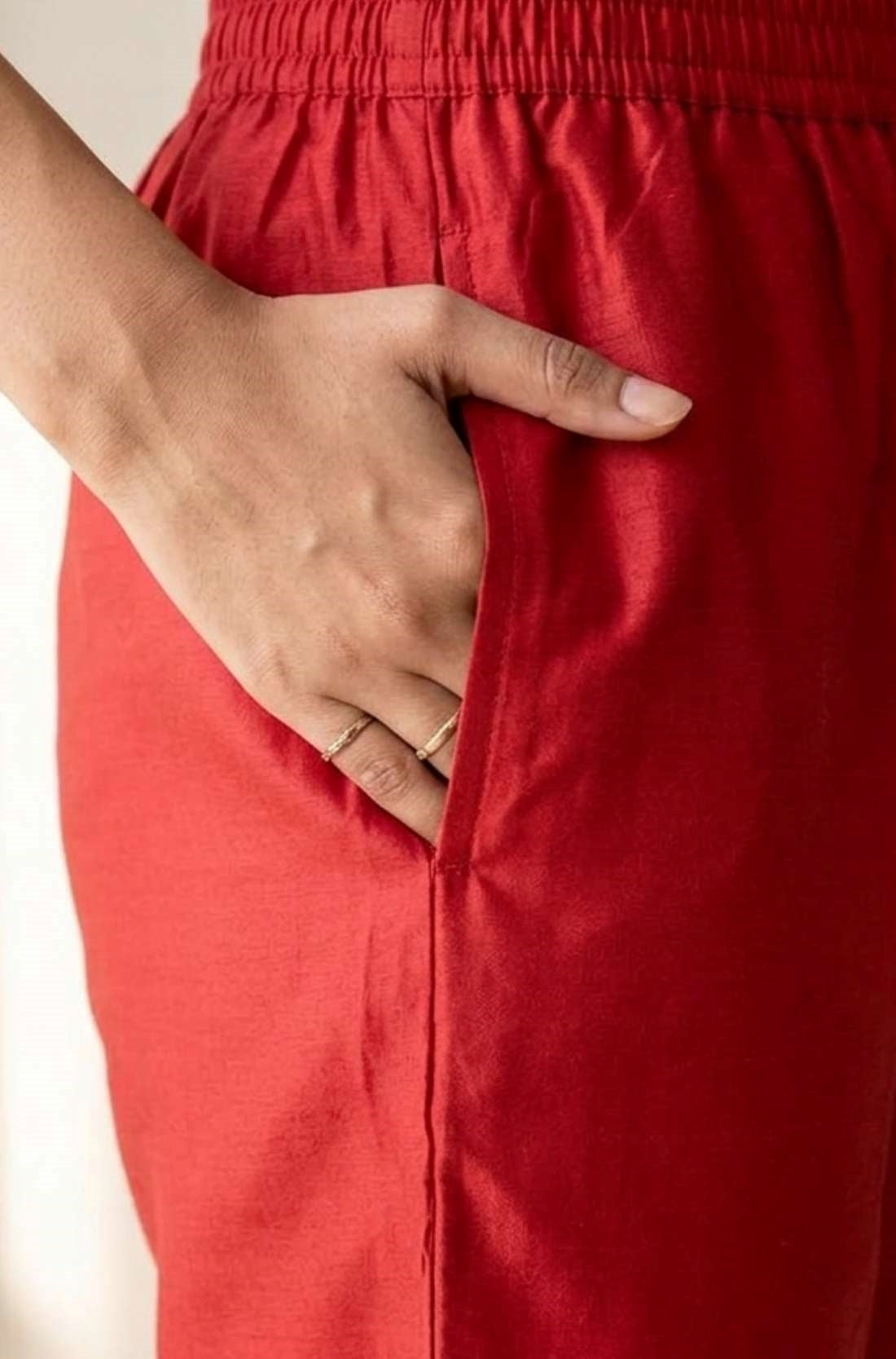 Close up view highlighting the convenient functional side utility pocket tailored into the matching straight trousers of a pashmina silk kurta set, showing a hand resting inside the pocket.