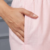 Close up view highlighting the convenient functional side utility pocket tailored into the straight pants of a pink pure cotton pintucks kurta set, showing a hand resting inside the pocket.
