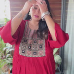 It is a video of a plus-size woman wearing a mirror-work maroon kurta showing its yoke detail and styling effortlessly