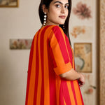 Side profile of the model wearing the orange pure handloom cotton tunic, highlighting the striped pattern and folded cuff sleeves.