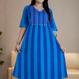 Model holding the hem of the Philippine blue handloom cotton pintucks tunic, showcasing its comfortable A-line flare and elbow-length cuffed sleeves.