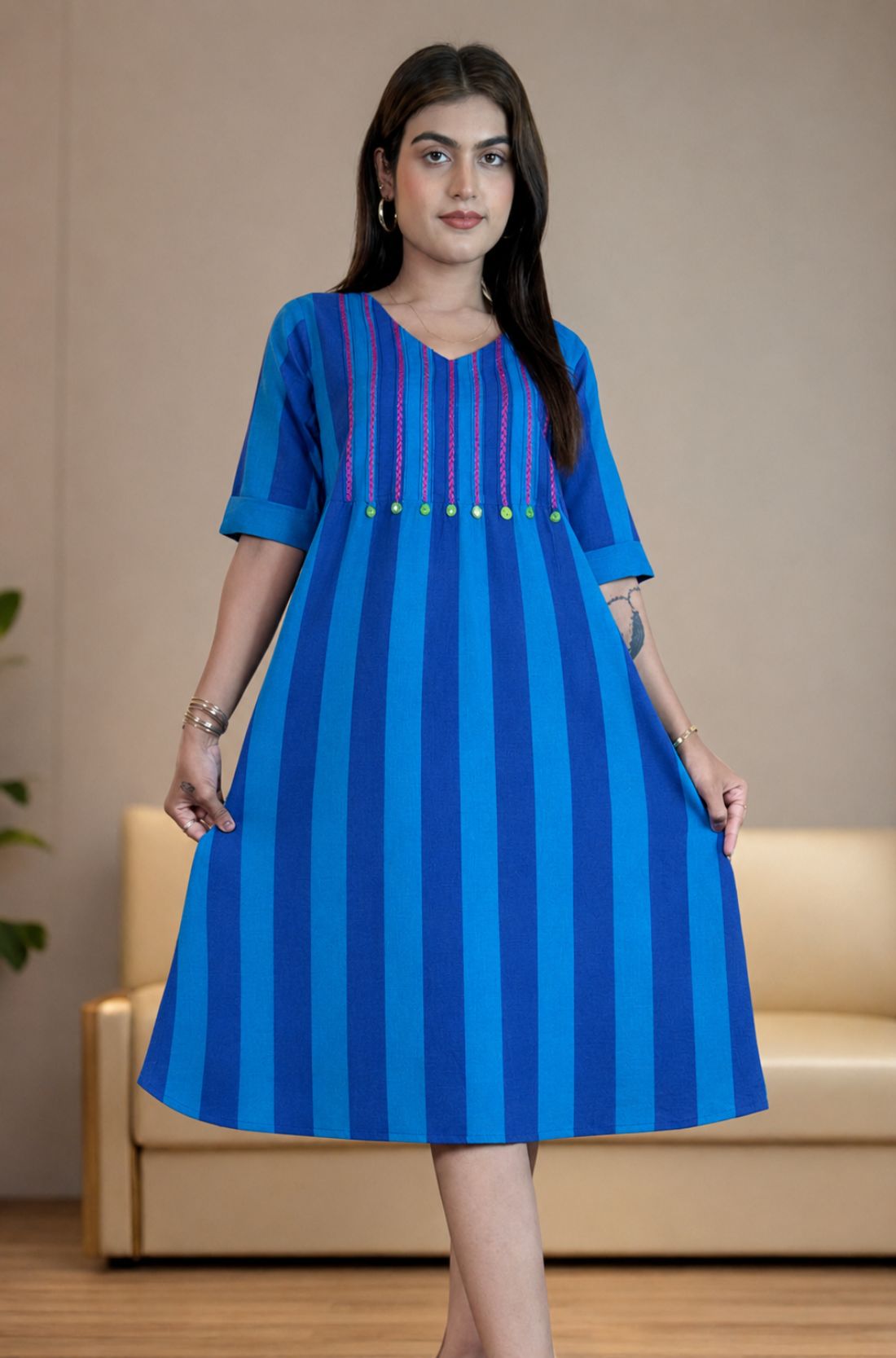 Model holding the hem of the Philippine blue handloom cotton pintucks tunic, showcasing its comfortable A-line flare and elbow-length cuffed sleeves.