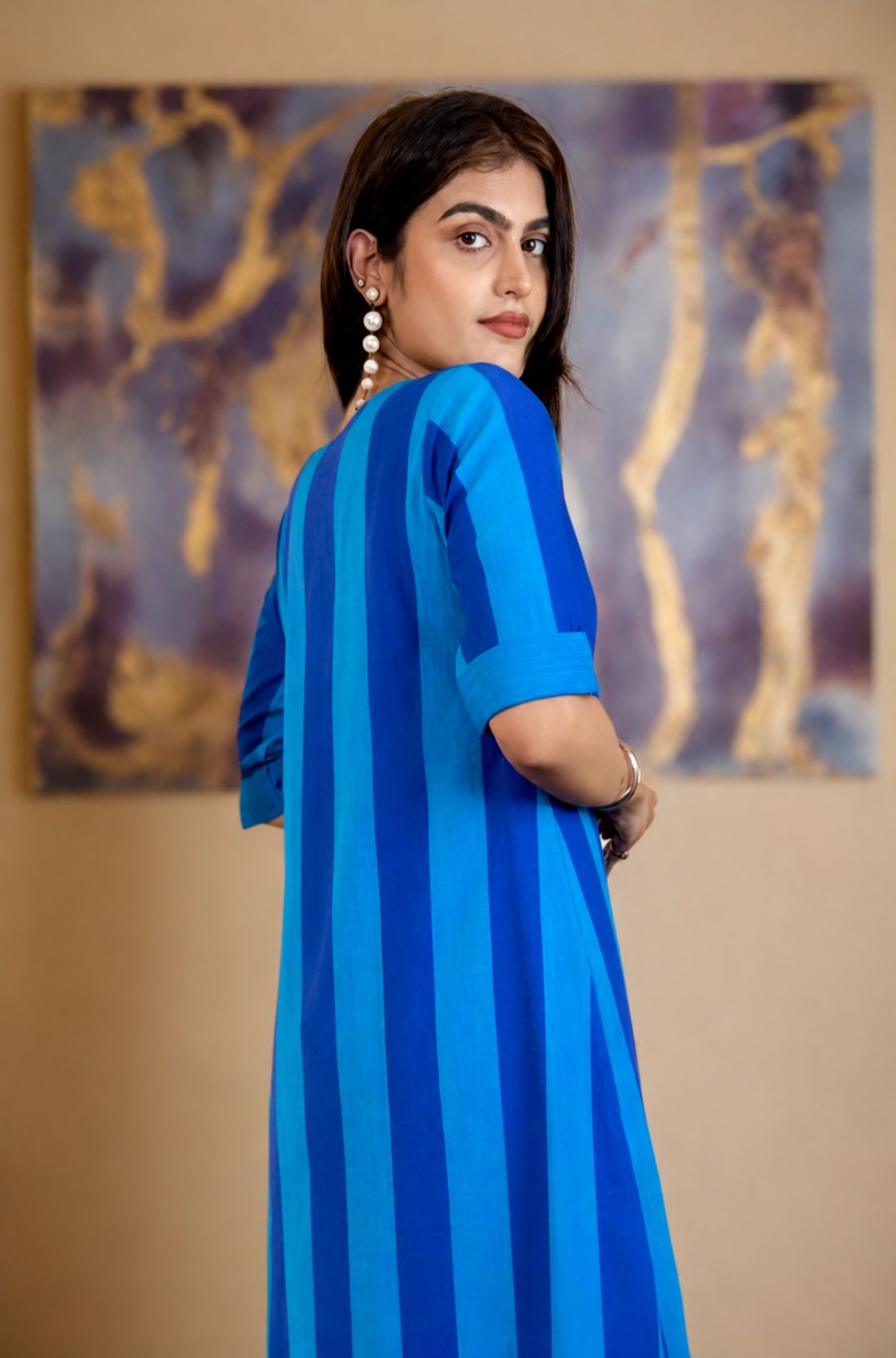 Model looking over her shoulder showing the back and side profile of the Philippine blue striped pure handloom cotton tunic dress.