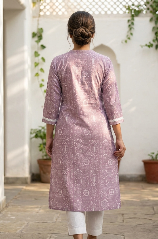 A rear view of a woman wearing a purple printed kurta with white trousers, highlighting the back silhouette.